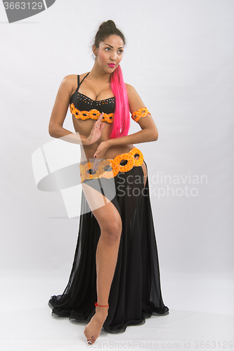 Image of Young girl mulatto dancing in a long black dress candid