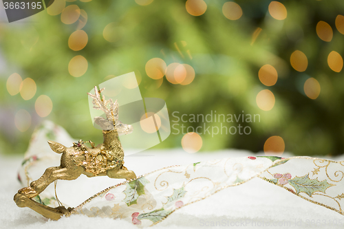 Image of Christmas Reindeer Ornament, Ribbon on Snow with Tree and Lights