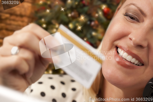 Image of Phone Holding Woman Credit Card In Front of Christmas Tree