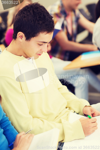 Image of group of smiling students with notebooks