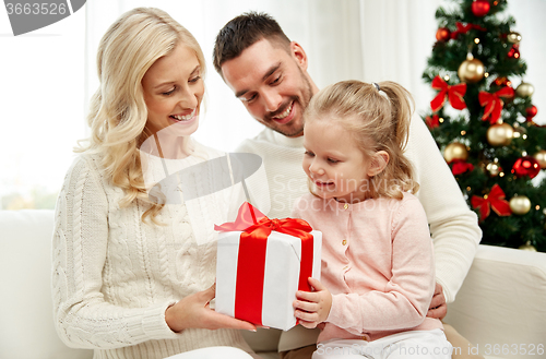 Image of happy family at home with christmas gift box