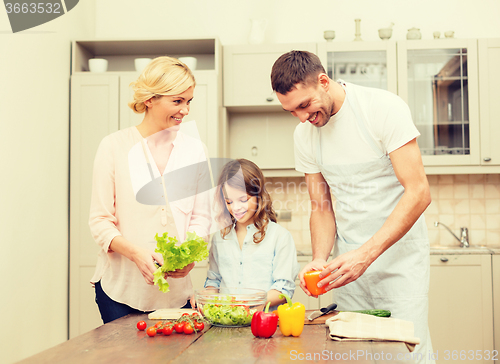 Image of happy family making dinner in kitchen