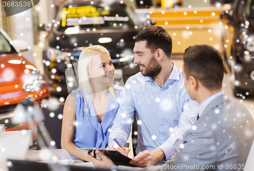Image of happy couple with car dealer in auto show or salon