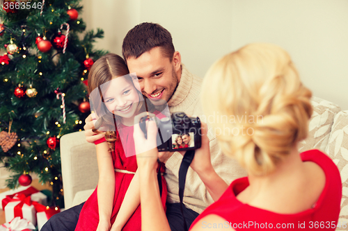 Image of mother taking picture of father and daughter