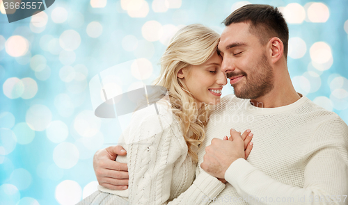 Image of happy couple over blue holidays lights background