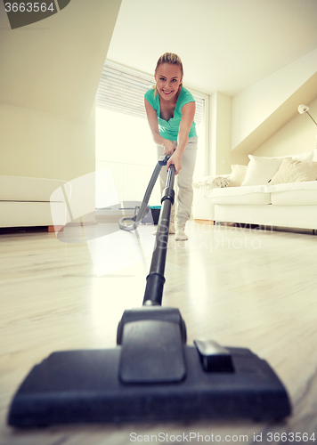 Image of happy woman with vacuum cleaner at home