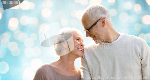 Image of happy senior couple over blue holidays lights