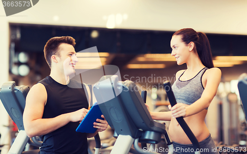 Image of woman with trainer exercising on stepper in gym