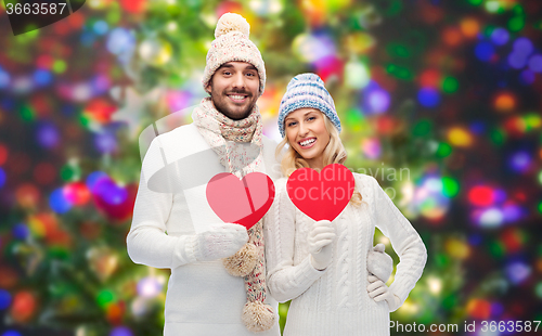 Image of smiling couple in winter clothes with red hearts