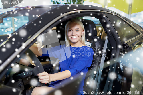 Image of happy woman inside car in auto show or salon