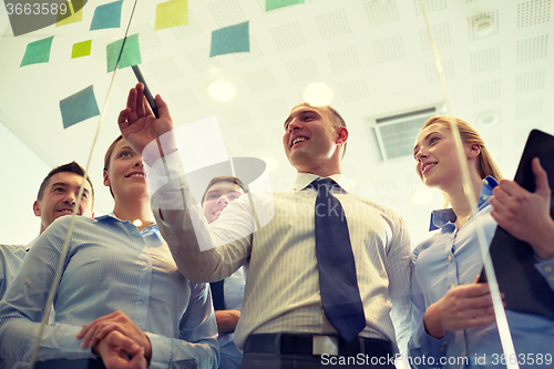 Image of smiling business people with marker and stickers