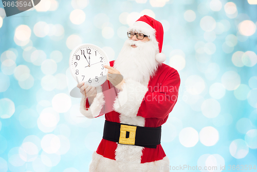 Image of man in costume of santa claus with clock