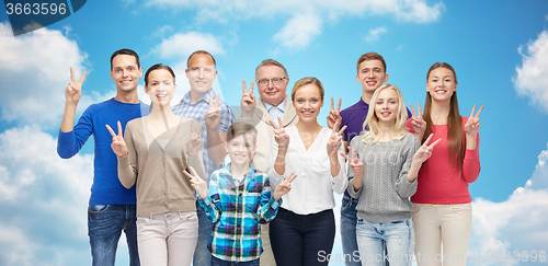 Image of group of smiling people showing peace hand sign