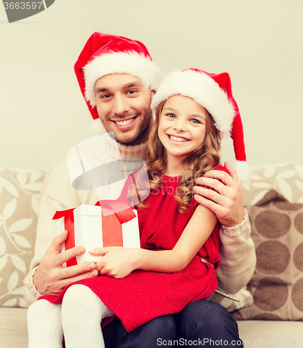 Image of smiling father and daughter holding gift box