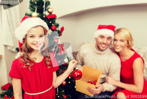 Image of smiling family decorating christmas tree