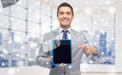 Image of happy businessman in suit showing tablet pc screen