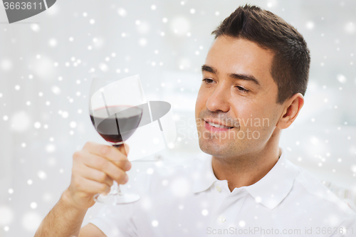 Image of happy man drinking red wine from glass