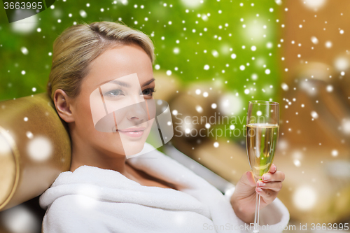 Image of beautiful young woman drinking champagne at spa