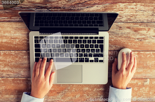 Image of close up of female hands with laptop and mouse