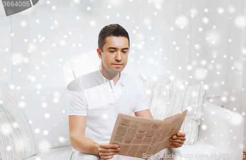 Image of man reading newspaper at home