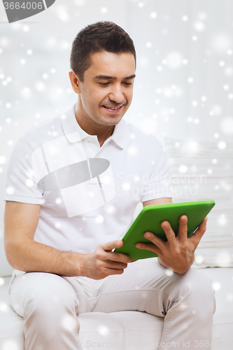 Image of smiling man working with tablet pc at home