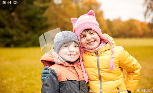 Image of happy little girl and boy in autumn park