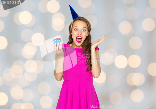 Image of happy woman or teen girl with birthday cupcake