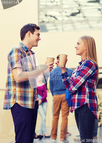 Image of group of smiling students with paper coffee cups