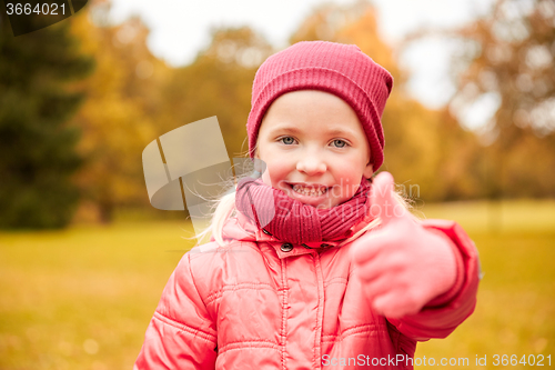 Image of happy little girl showing thumbs up in autumn park