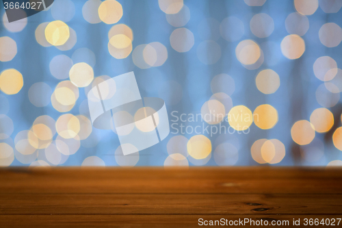 Image of empty wooden table with christmas golden lights