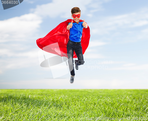 Image of boy in super hero cape and mask showing thumbs up