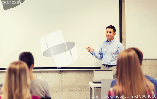 Image of group of students and smiling teacher in classroom