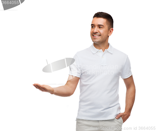 Image of smiling man showing something on empty palm