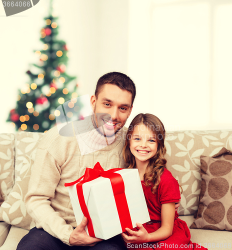 Image of smiling father and daughter holding gift box