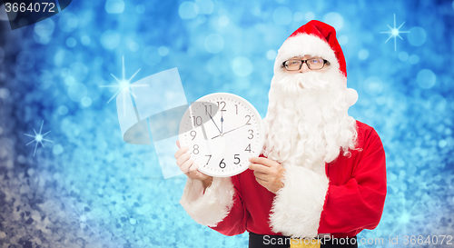 Image of man in costume of santa claus with clock