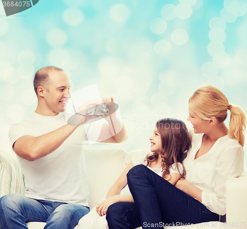 Image of happy family with camera at home