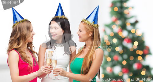 Image of three women wearing hats with champagne glasses