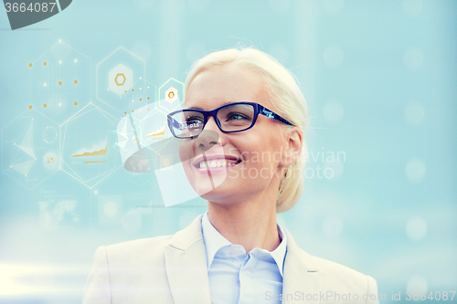 Image of young smiling businesswoman in eyeglasses outdoors