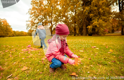 Image of children collecting leaves in autumn park