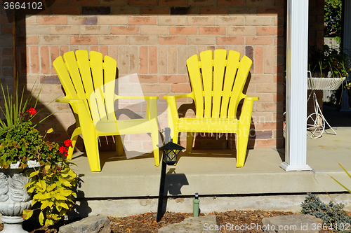 Image of Two yellow wooden chairs.