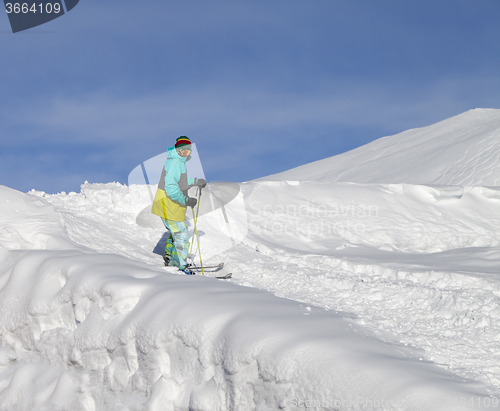 Image of Skier on off-piste slope in sun day