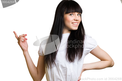Image of Pretty woman pointing finger towards blank space