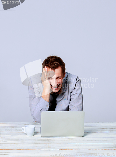 Image of Happy man working on laptop in the office