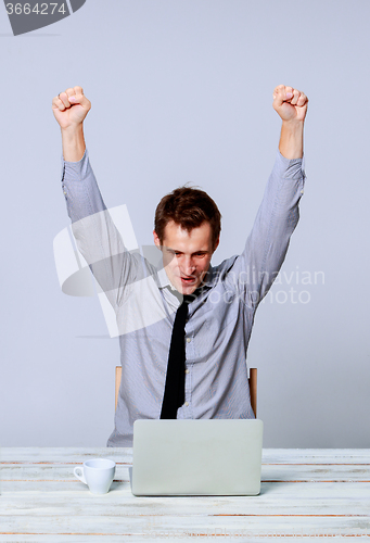 Image of Happy man working on laptop in the office