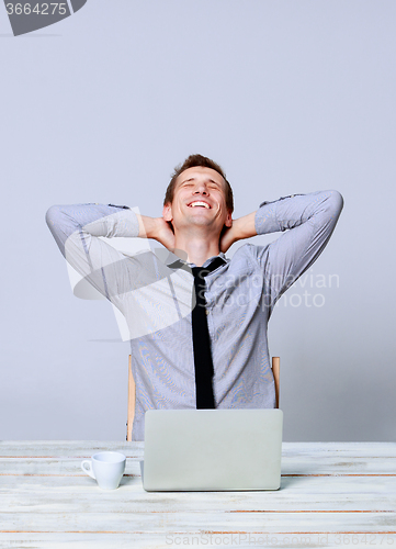 Image of Happy man working on laptop in the office