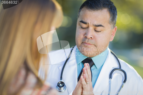 Image of Hispanic Male Doctor Praying With A Patient