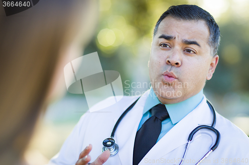 Image of Hispanic Male Doctor or Nurse Talking With a Patient