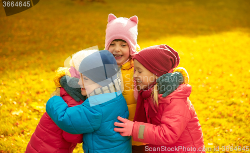 Image of group of happy children hugging in autumn park