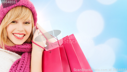 Image of woman in pink hat and scarf with shopping bags