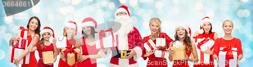 Image of santa calaus and happy women with gift boxes